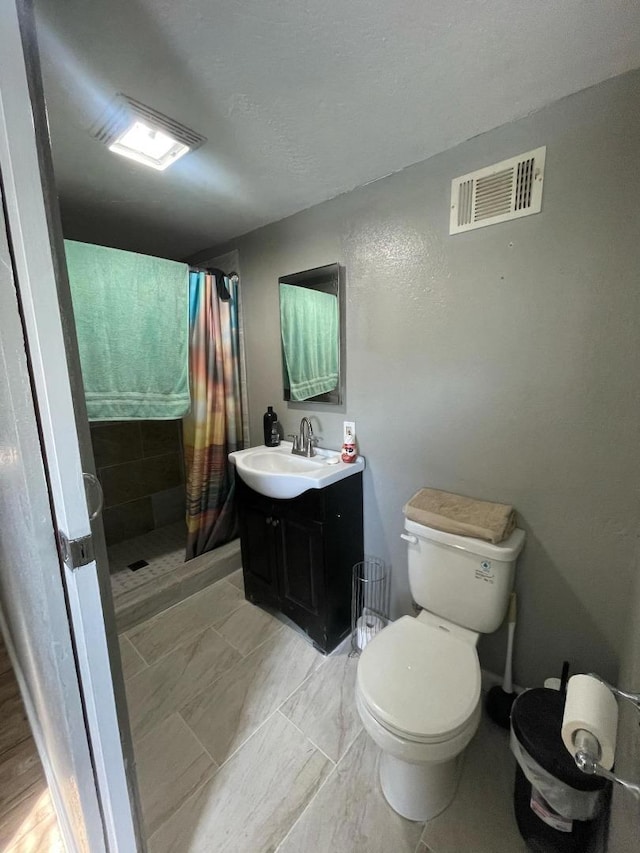 bathroom featuring a shower with curtain, vanity, and toilet