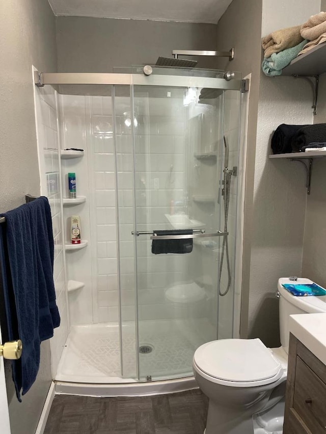 bathroom with vanity, an enclosed shower, and toilet