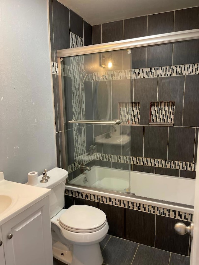 full bathroom with tile patterned floors, vanity, toilet, and combined bath / shower with glass door