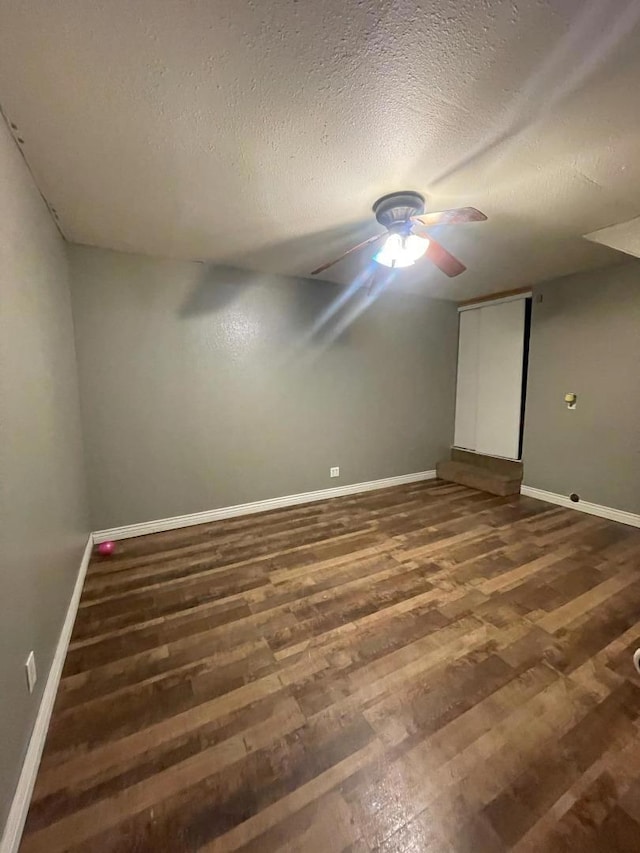 empty room featuring a textured ceiling and dark wood-type flooring