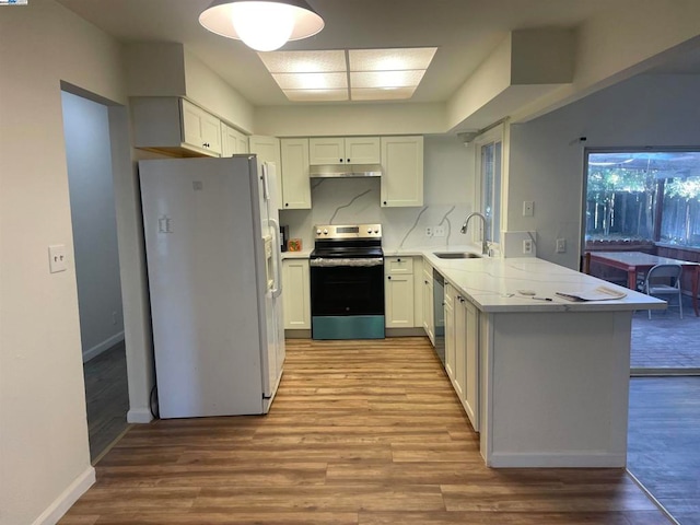 kitchen featuring light hardwood / wood-style floors, white cabinetry, kitchen peninsula, stainless steel appliances, and sink