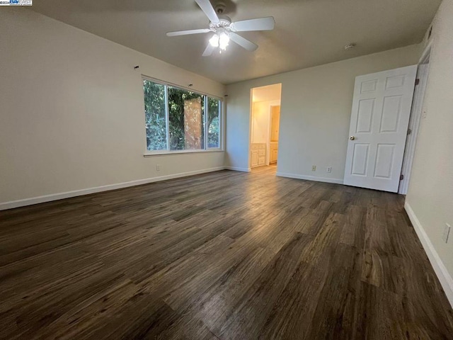 unfurnished bedroom with ensuite bath, ceiling fan, and dark wood-type flooring