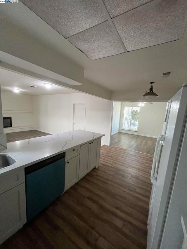 kitchen with dishwasher, dark wood-type flooring, sink, white cabinetry, and a drop ceiling