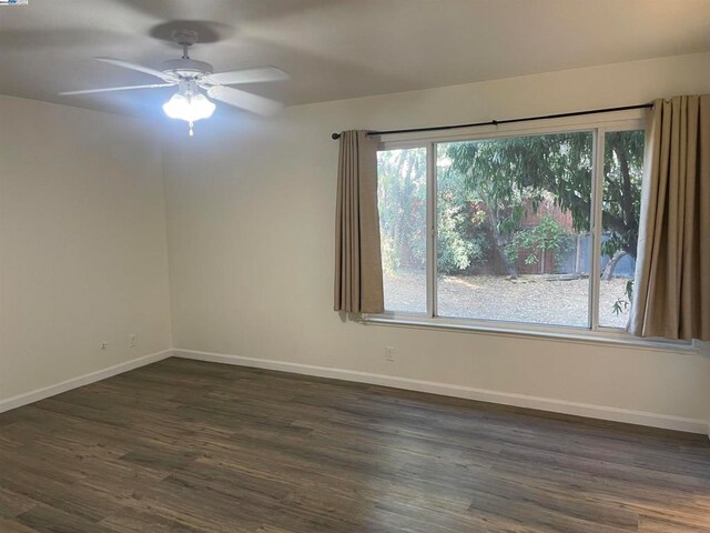 empty room with ceiling fan and dark hardwood / wood-style floors