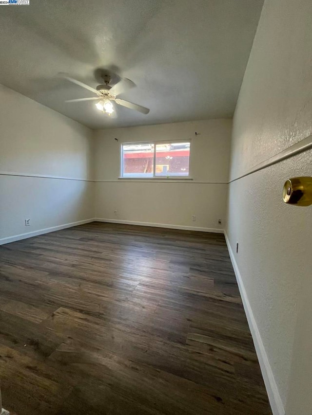 spare room with ceiling fan and dark wood-type flooring