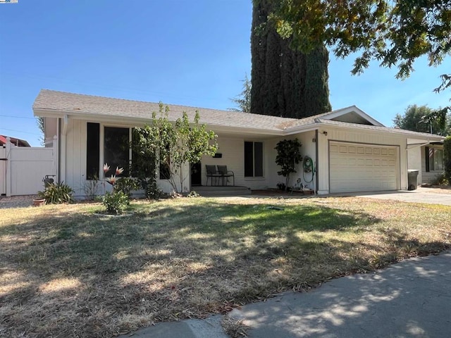 ranch-style house featuring a front lawn and a garage