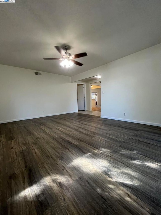 empty room with ceiling fan and dark wood-type flooring