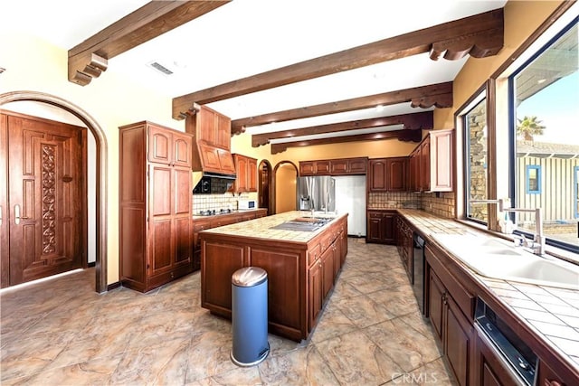 kitchen featuring tile countertops, decorative backsplash, and a center island