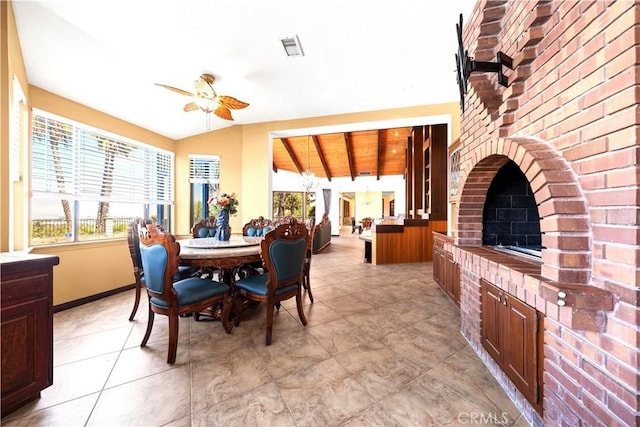 dining area featuring ceiling fan, vaulted ceiling with beams, wood ceiling, and a brick fireplace