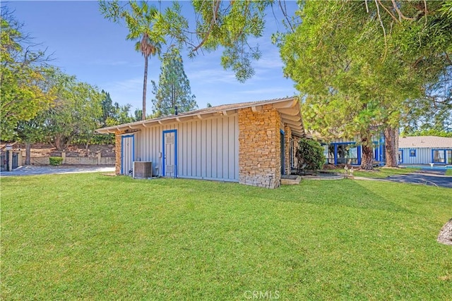 view of outbuilding featuring central AC and a lawn