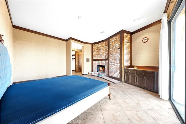 bedroom with ensuite bath, a large fireplace, sink, and ornamental molding