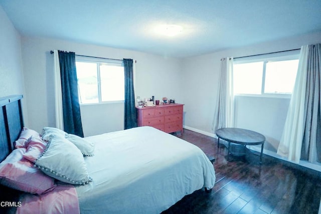 bedroom with dark hardwood / wood-style floors