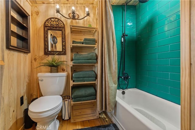 bathroom with tiled shower / bath, hardwood / wood-style floors, and toilet