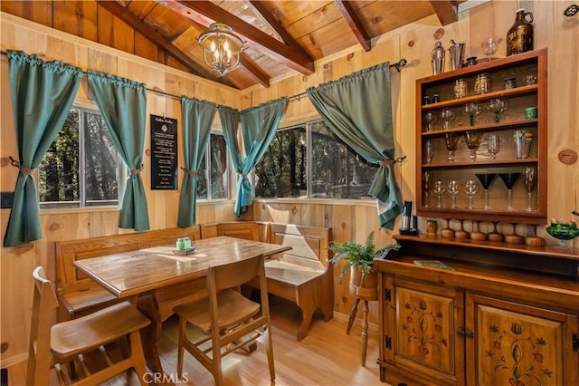 sitting room with vaulted ceiling with beams, wood ceiling, wood walls, a chandelier, and light hardwood / wood-style flooring