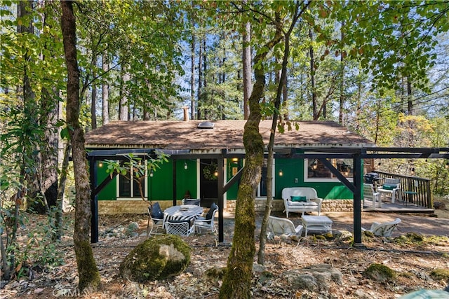 view of front facade with a wooden deck and a patio