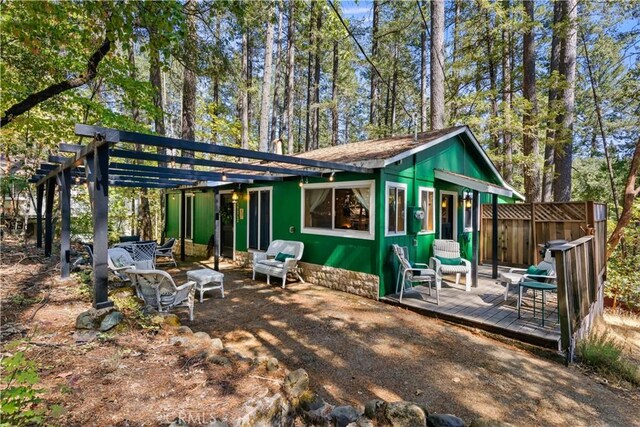 rear view of property with a pergola and a deck