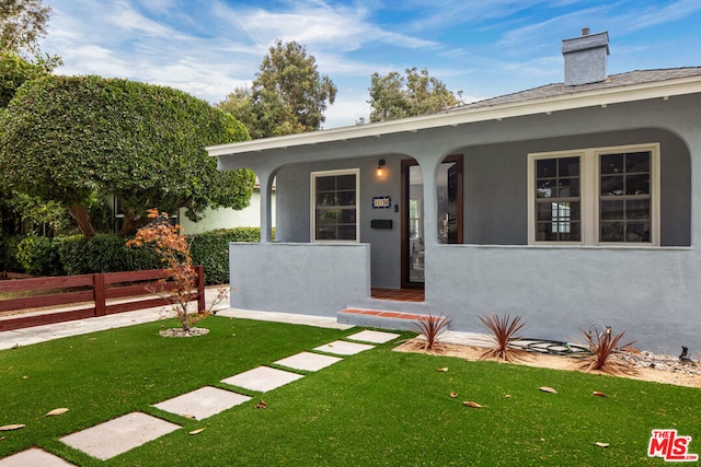 view of exterior entry with a lawn