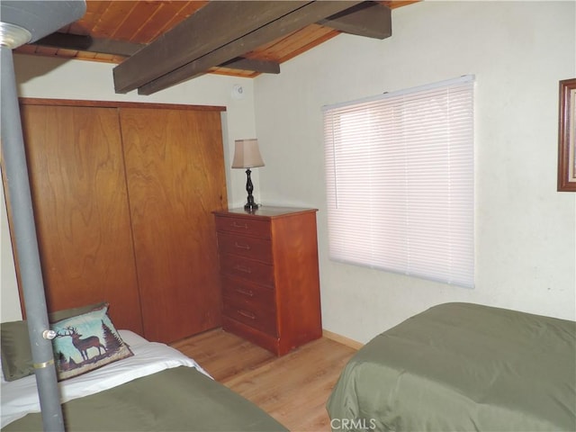 bedroom featuring lofted ceiling with beams, wooden ceiling, and light hardwood / wood-style flooring