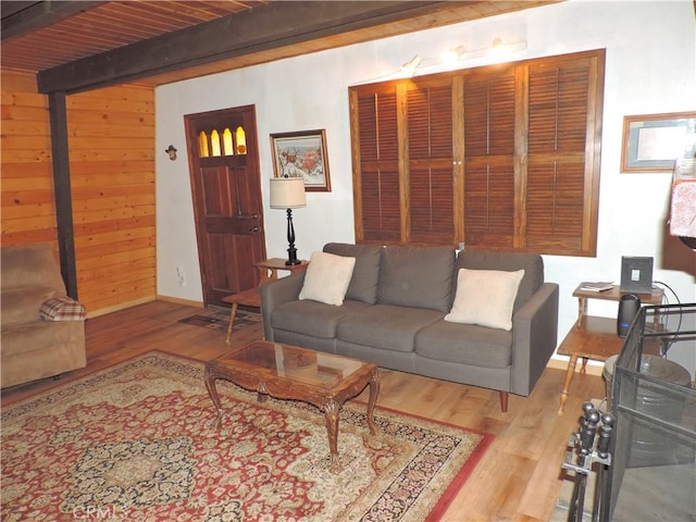 living room featuring wood ceiling, beam ceiling, wood walls, and light wood-type flooring