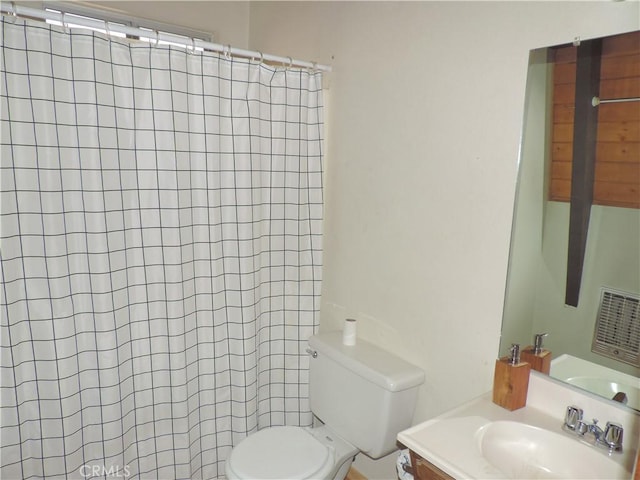 bathroom featuring vanity, curtained shower, and toilet