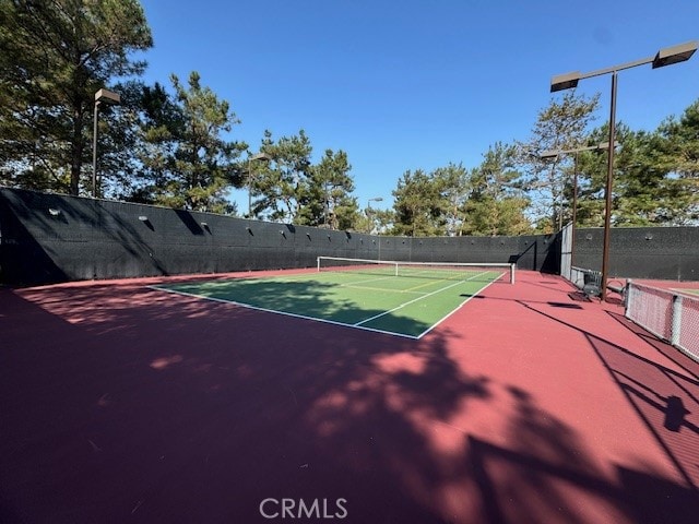 view of tennis court featuring basketball hoop