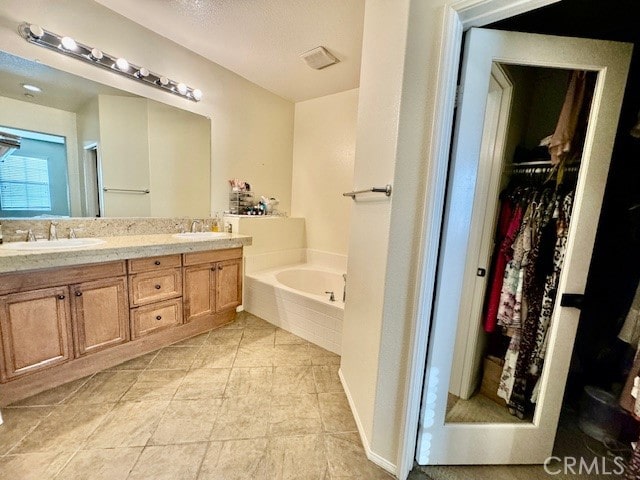 bathroom featuring vanity and tiled tub