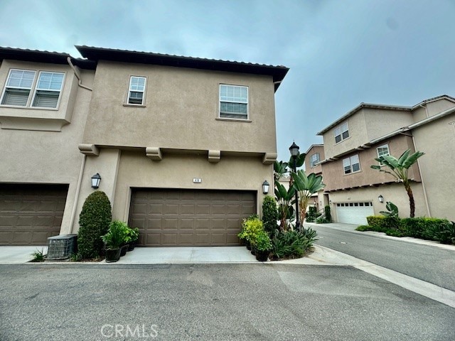 view of front of home with central AC unit and a garage