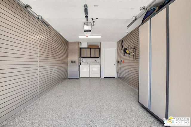 garage featuring independent washer and dryer and a garage door opener