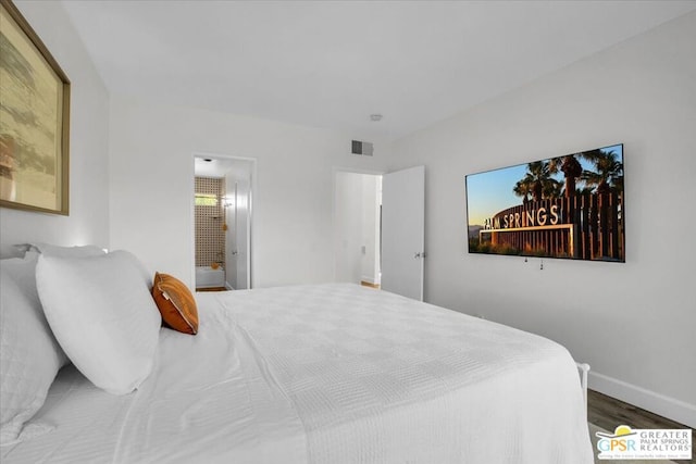 bedroom featuring hardwood / wood-style flooring and ensuite bath