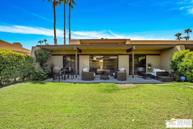 back of property with an outdoor living space, a patio area, and a lawn