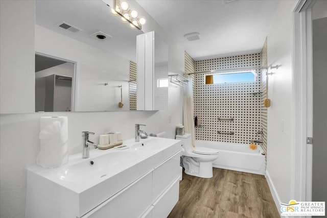 full bathroom with vanity, toilet, tiled shower / bath, and hardwood / wood-style flooring