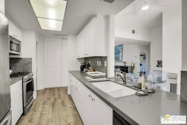 kitchen featuring white cabinets, light hardwood / wood-style floors, sink, and appliances with stainless steel finishes