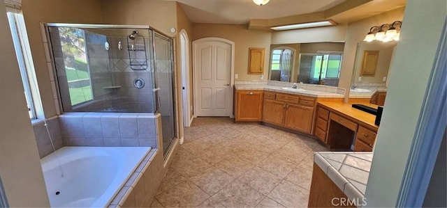 full bathroom with vanity, a garden tub, and a stall shower