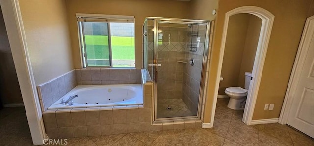 full bathroom featuring tile patterned floors, a shower stall, a jetted tub, and toilet