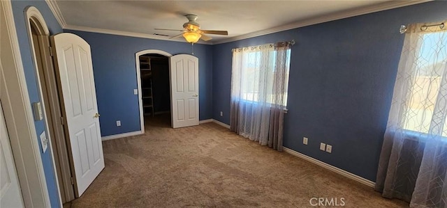 unfurnished bedroom with crown molding, multiple windows, and carpet