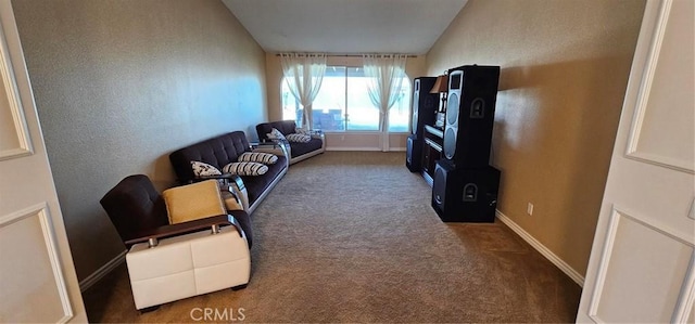 living area featuring vaulted ceiling, a textured wall, baseboards, and carpet floors