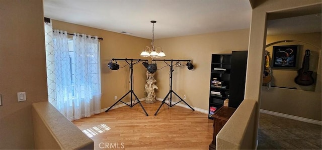 dining space featuring wood finished floors, baseboards, and a chandelier