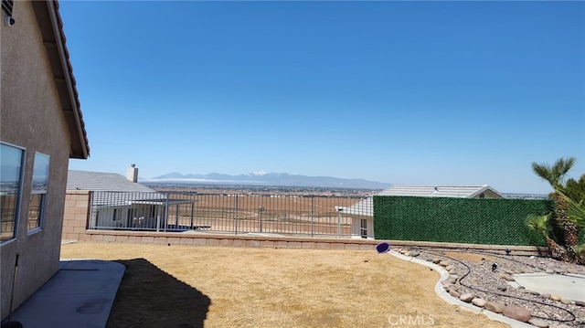 view of yard featuring a fenced backyard and a mountain view