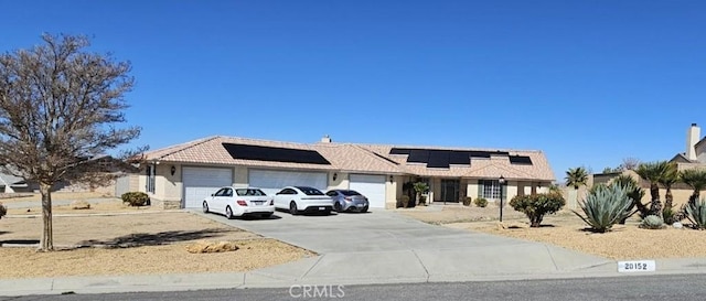 ranch-style house with solar panels, stucco siding, concrete driveway, a garage, and a tile roof