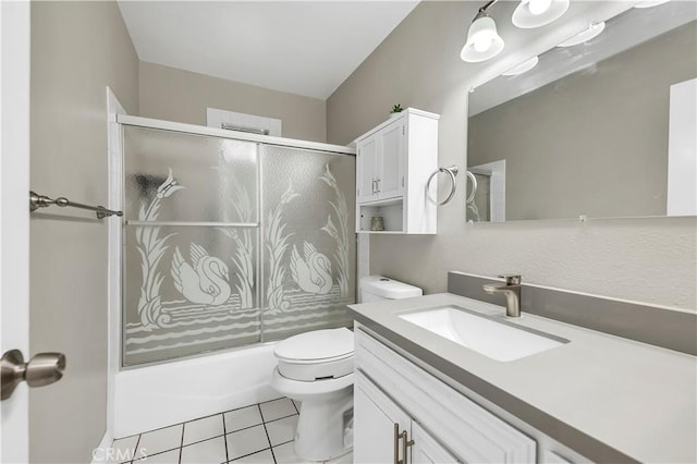 full bathroom with tile patterned flooring, vanity, bath / shower combo with glass door, and toilet