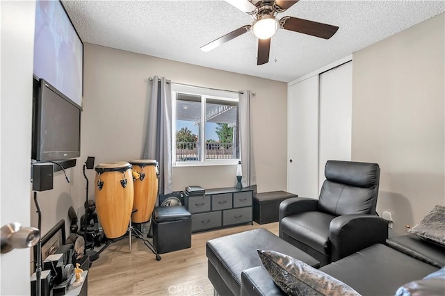 sitting room featuring a textured ceiling, light hardwood / wood-style floors, and ceiling fan