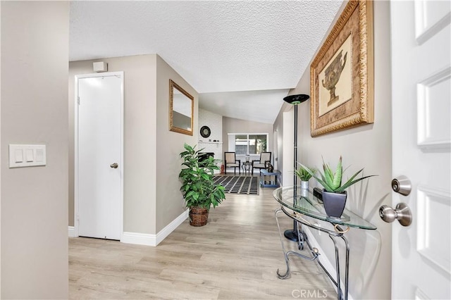 1186 Bottle Tree Way, Hemet, CA 92545 - corridor with light wood-style flooring, vaulted ceiling, and a textured ceiling