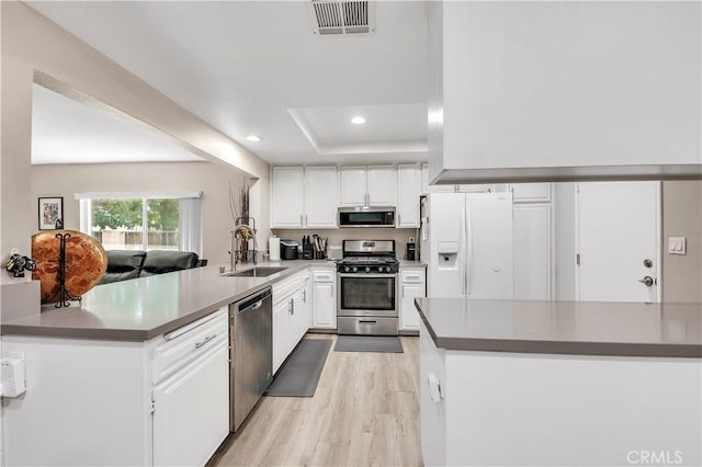1186 Bottle Tree Way, Hemet, CA 92545 - kitchen featuring appliances with stainless steel finishes, light wood-style floors, a peninsula, white cabinetry, and recessed lighting