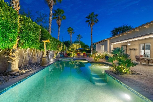 pool at twilight with a patio