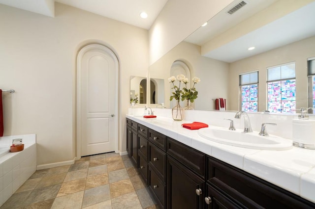 bathroom with vanity and a bath