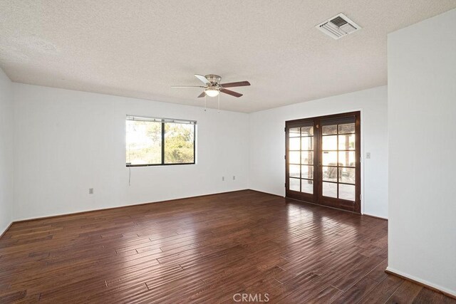 unfurnished room featuring french doors, dark wood-type flooring, and a textured ceiling