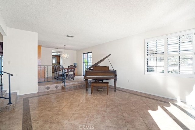 misc room featuring a textured ceiling, light tile patterned floors, and a notable chandelier