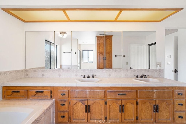 bathroom featuring tiled bath and vanity