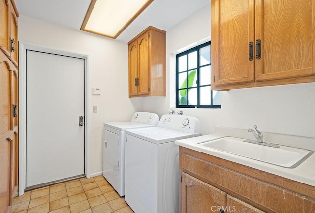 laundry area featuring cabinets, light tile patterned floors, sink, and washing machine and dryer