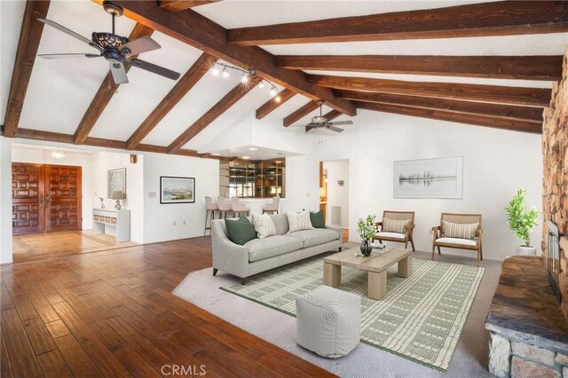 living room featuring wood-type flooring, beamed ceiling, and high vaulted ceiling